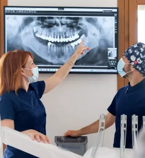 La dottoressa Lara Zanon indica una radiografia panoramica sullo schermo, il dottor Gabriele Rossi la guarda.